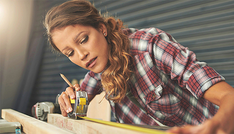 A woman focuses on her project, skillfully using a measuring tool to achieve her objectives - office and dry containers
