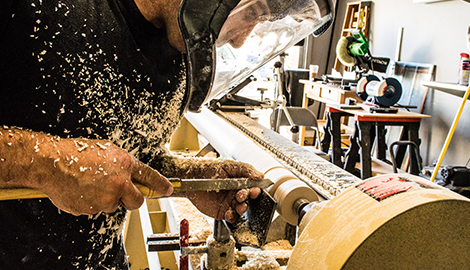 A skilled man uses a woodworking machine, diligently shaping wood as part of his craftsmanship in a workshop - office and dry containers
